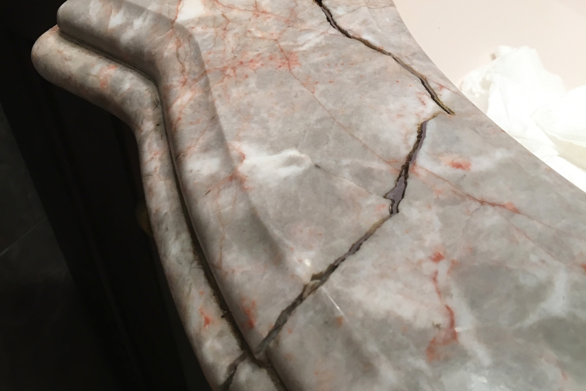 A cracked gray and pink marble stone countertop