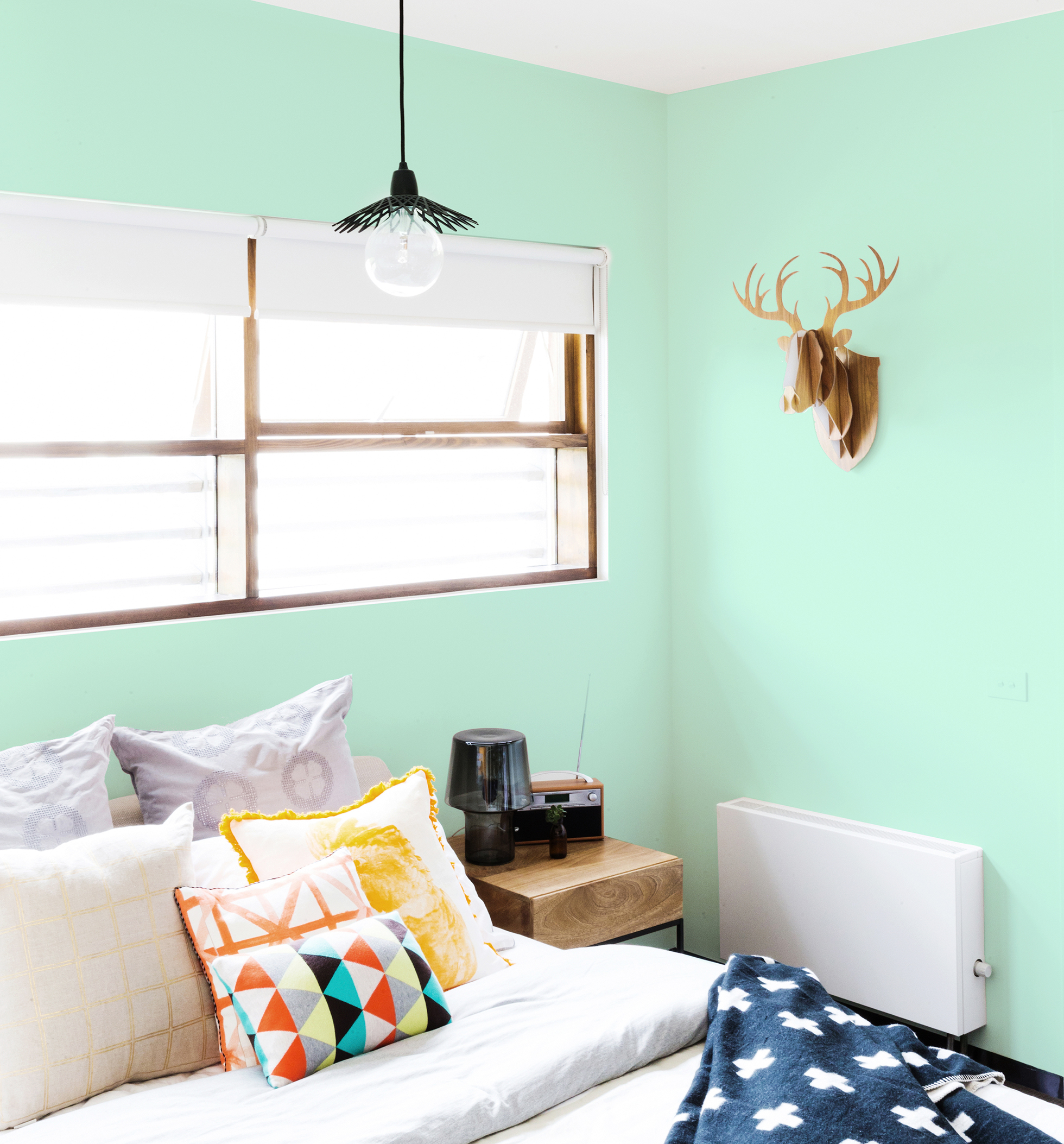 Green bedroom with large window and cardboard deer head