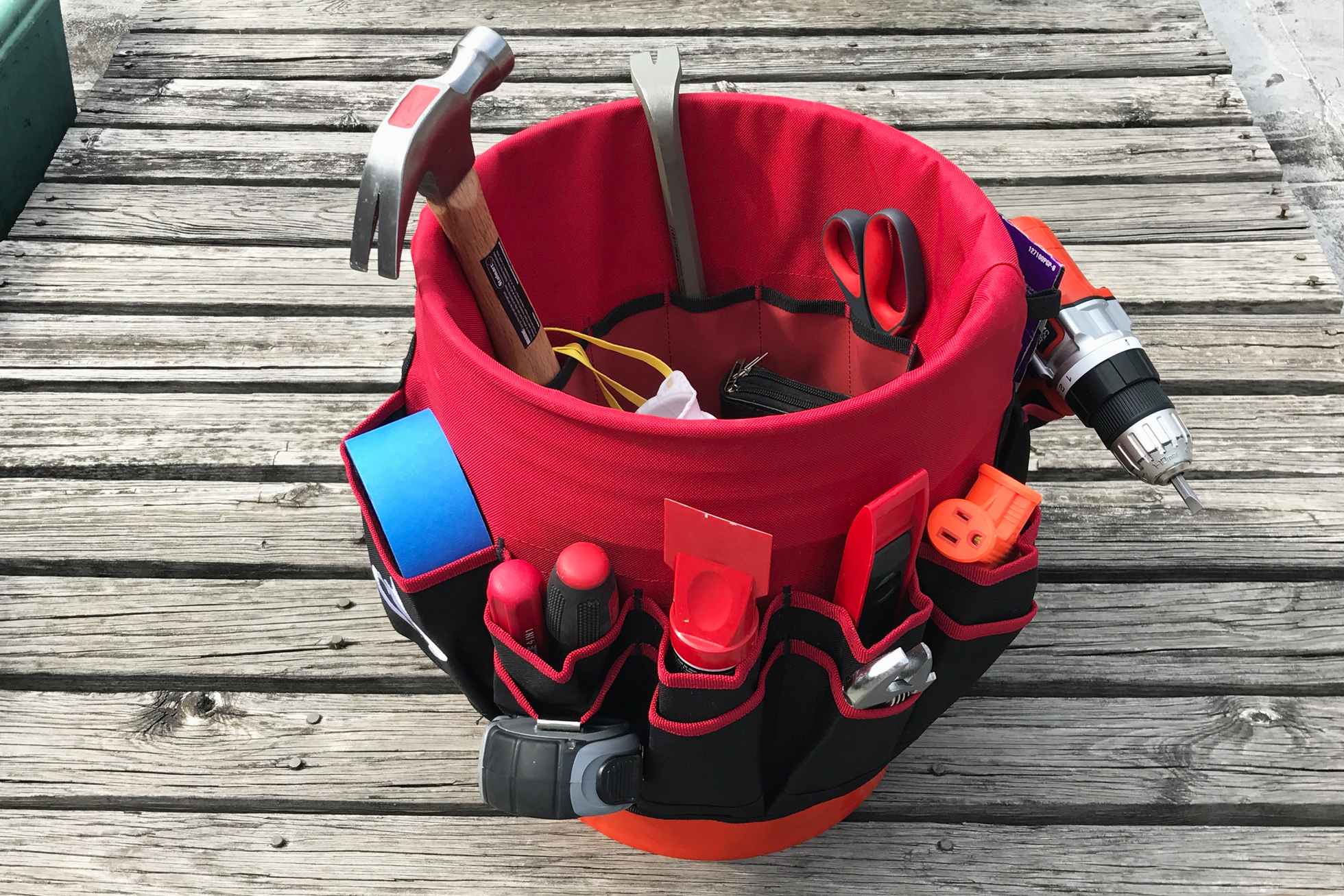 A red tool bucket liner in a bucket filled with hardware