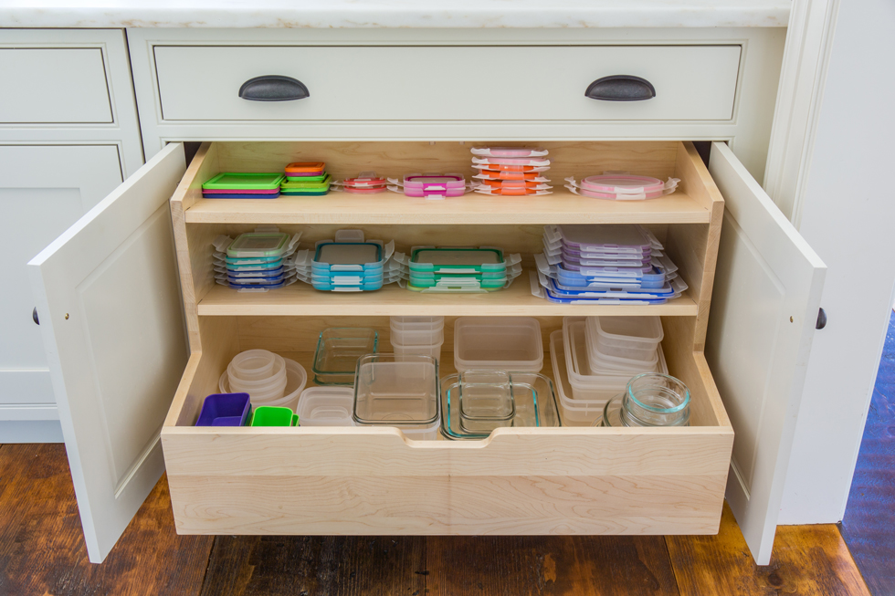 Colorful Tupperware lids in a wood kitchen drawer
