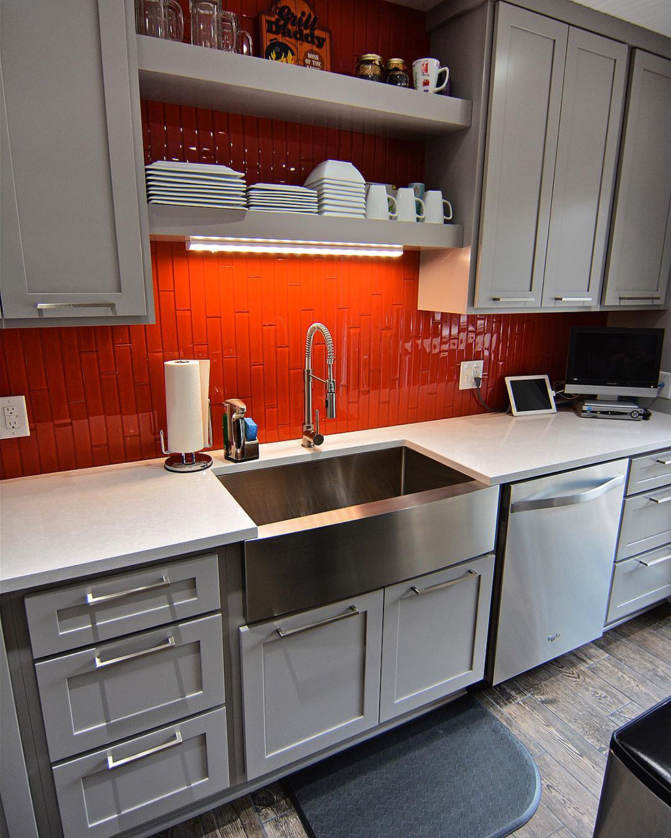 Orange tile backsplash in white kitchen with stainless sink