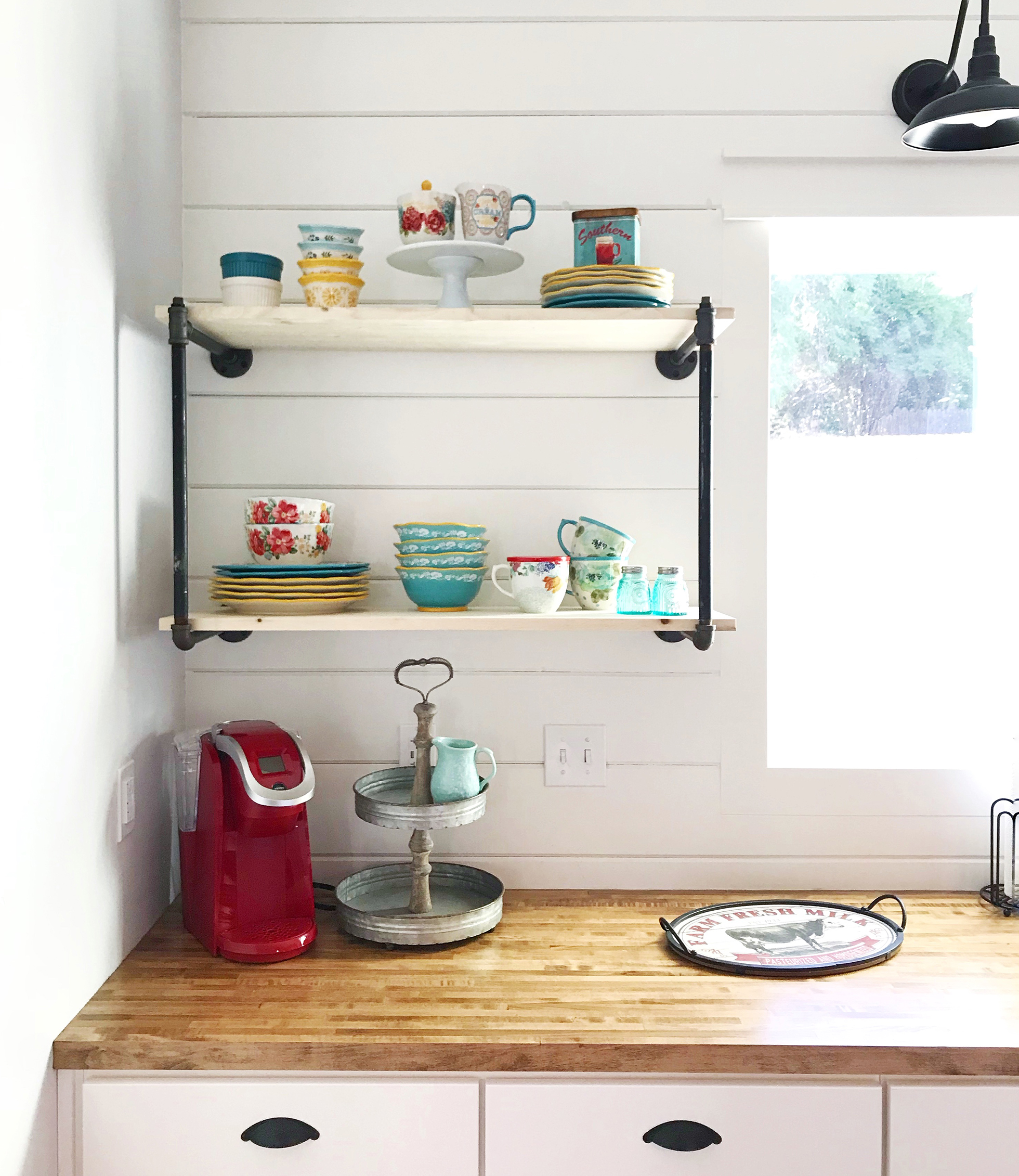 Gas-pipe shelving with vintage china in white kitchen