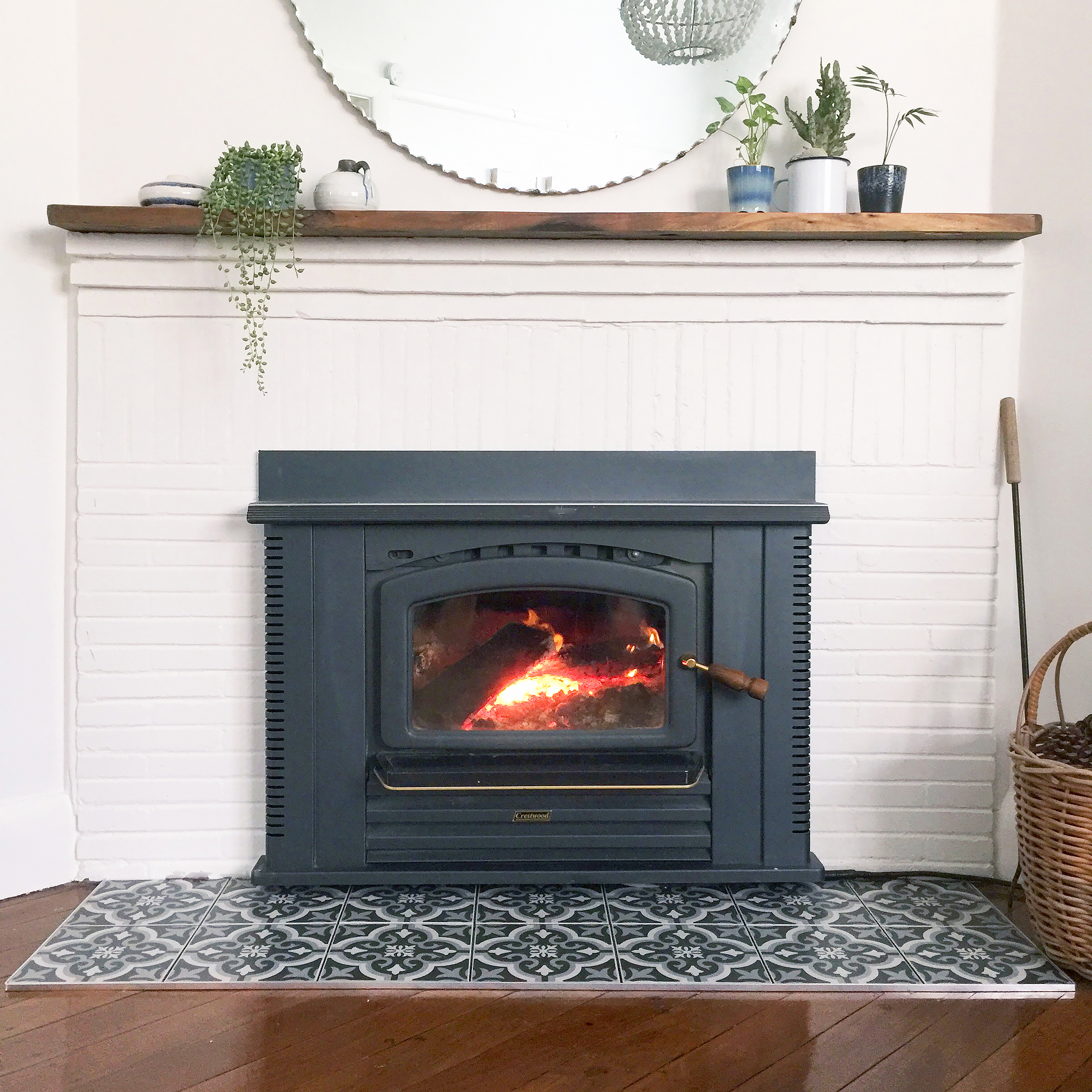 A beige-painted brick fireplace with black slate tiles