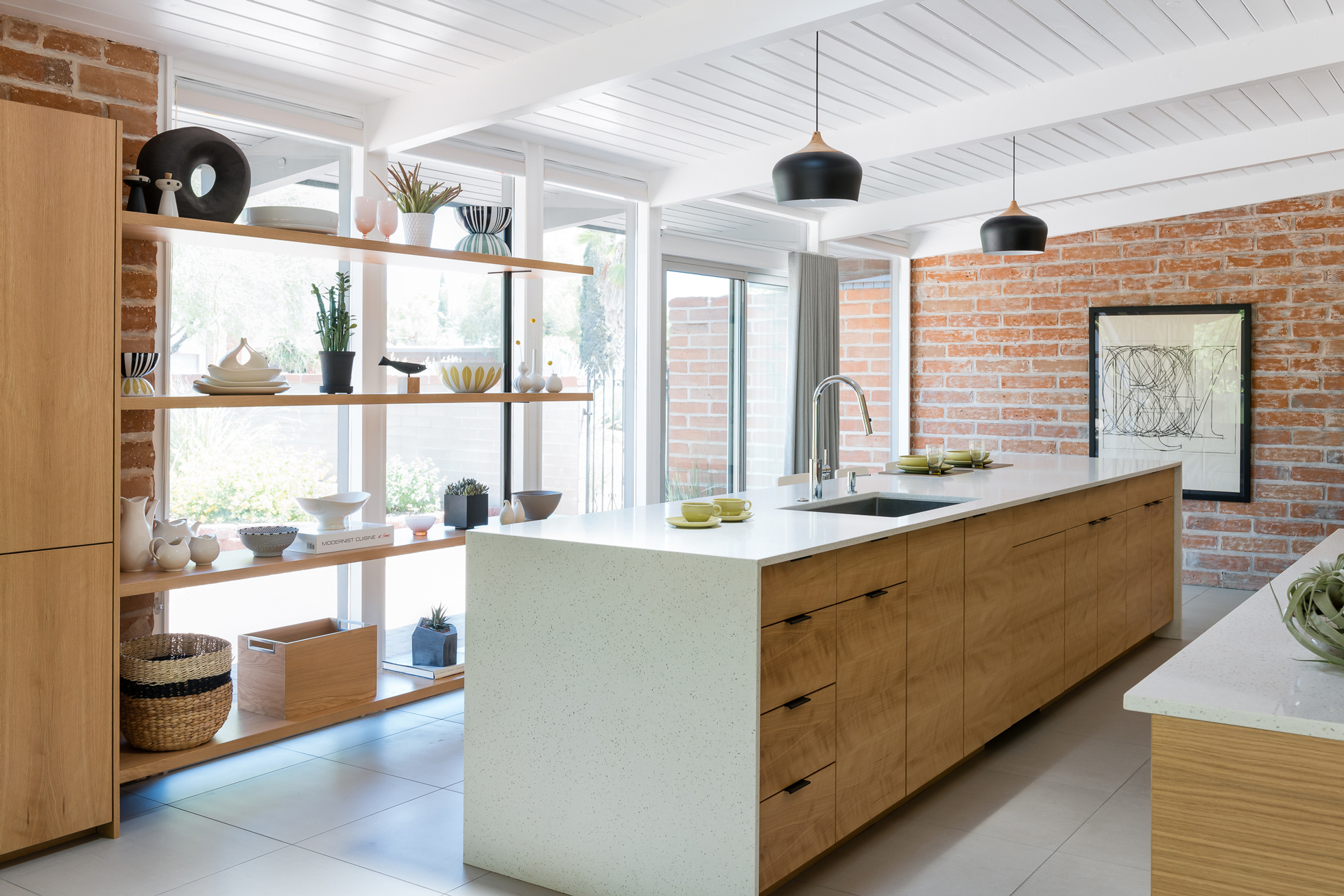A bright kitchen with open shelving and wall of windows